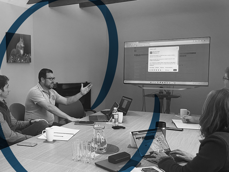 the team presenting to clients in a board room